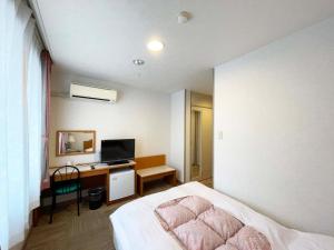 a bedroom with a bed and a desk with a television at Hotel Ginsui - Vacation STAY 58198v in Kanayama