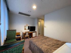 a hotel room with a bed and a desk and chair at Hotel Ginsui - Vacation STAY 58198v in Kanayama
