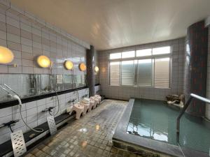 a bathroom with a tub and a dog laying in the water at Marina Hotel Kaikuu - Vacation STAY 58563v in Kanayama