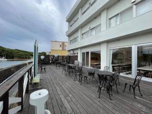 a deck with tables and chairs next to a building at Marina Hotel Kaikuu - Vacation STAY 58549v in Kanayama