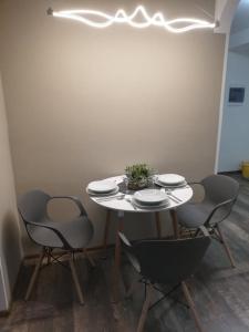 a white table with four chairs and plates on it at Apartmány Rosijo in Lednice