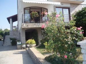 Casa con balcón con rosas rosas en Guest House Lidija, en Matulji
