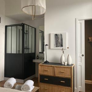 a bedroom with a black door and a wooden dresser at la boutique mj décoration vous propose de découvrir ses deux chambres d'hôtes in Doué-la-Fontaine