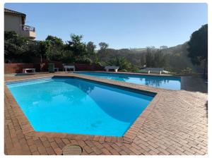 a large swimming pool with blue water at Walk To Beach 704 Umdloti Holiday Resort in Umdloti
