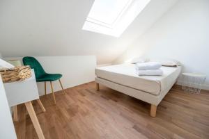 - une chambre avec un lit et une chaise verte dans l'établissement Le Poulorio 12 - T2 - Proche Gare - dernier étage By Locly, à Lorient
