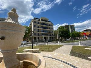 a statue in a park with a building in the background at Rabi Park Residence in Varna City