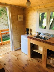 a kitchen with a sink and a refrigerator at ROULOTTE DE CHARME in Saint-Genest-de-Bauzon