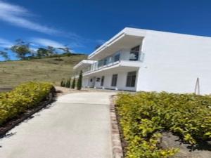 a white house on a hill with a driveway at Hotel Takuara in Vergara