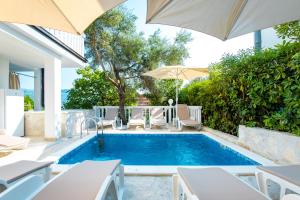 a swimming pool with chairs and an umbrella at Boka 2 in Krašići +55 photos