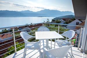 a table and chairs on a balcony with a view of the water at Boka 2 in Krasici