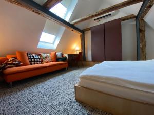 een slaapkamer met een bed en een bank in een kamer bij Isabella Living in Maribor
