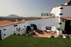 a patio with two chairs and a table on a house at Casa Natura 23 in San Bartolomé