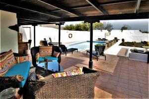 eine Terrasse mit Stühlen und einem Pool in der Unterkunft Casa Natura 23 in San Bartolomé