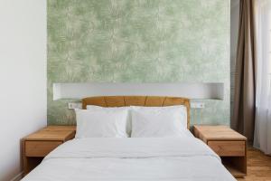 a bedroom with a white bed with a green wall at CLUJ-NAPOCA coeur de ville in Cluj-Napoca
