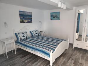 una camera da letto con un letto bianco con cuscini blu di Pensiune Blue Coral Jurilovca a Jurilovca