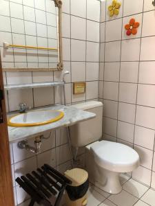 a small bathroom with a toilet and a sink at Porto do Sol - Chalé 21 in Pipa