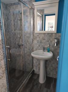 y baño con lavabo y ducha. en Pensiune Blue Coral Jurilovca en Jurilovca