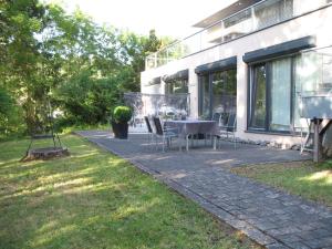 een patio met een tafel en stoelen naast een gebouw bij RING-RACE-FLATS Appartements in Adenau