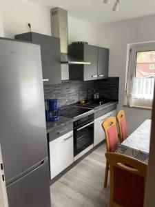 a kitchen with stainless steel appliances and a table with chairs at Ferienhaus Bockswiese in Goslar