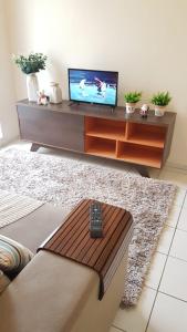 a living room with a television and a remote control at Apartamento TOP CLIMATIZADO em CRICIÚMA-SC - ótimo CUSTO-BENEFÍCIO - Cozinha completa - Cama Box - WiFI - Smart TV - Apps YouTube - NetFlix - Prime Vídeo - Garagem coberta - Portaria Digital 24h - Lugar sossegado e arborizado - Acomoda até 5 pessoas in Criciúma