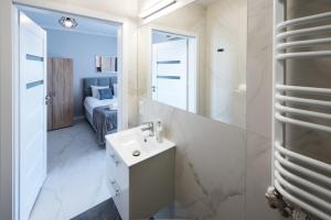 a bathroom with a sink and a mirror at Estella Apartment in Krakow