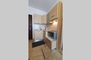 a small kitchen with white cabinets and a microwave at Vasilikis design appartment in Amalias