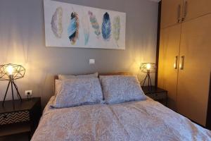 a bedroom with a bed with two pillows and two lamps at Vasilikis design appartment in Amalias
