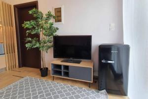 a living room with a flat screen tv and a tv stand at Vasilikis design appartment in Amalias