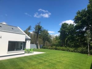 einen Garten mit grünen Stühlen und einem weißen Haus in der Unterkunft Hilltown Lodges No4 in Hilltown