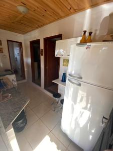 une cuisine avec un réfrigérateur blanc dans une pièce dans l'établissement Chalé Flor da Serra, à Conceição da Ibitipoca 5 autres photos