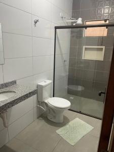 uma casa de banho com um WC e uma cabina de duche em vidro. em Casa Afonso Pena II em Bonito