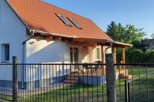 una casa con tetto arancione e recinzione di Andrea nyaralóház a Kővágóörs