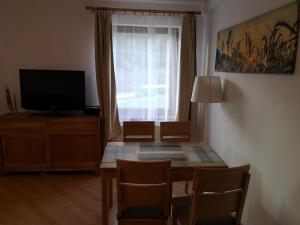 a living room with a table with chairs and a television at Telgárt Apartmán č.12 in Telgárt