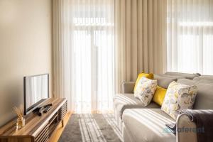 - un salon avec un canapé et une télévision dans l'établissement Light-filled Bonjardim Apartments, à Porto