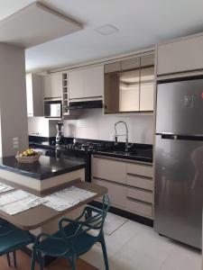 a kitchen with a table and chairs and a kitchen with stainless steel appliances at Conforto em Condomínio Frente Mar in Barra Velha