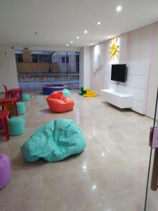 a room with colorful chairs and a flat screen tv at Conforto em Condomínio Frente Mar in Barra Velha +39 photos