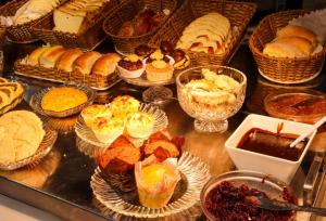 a display case filled with lots of different types of pastries at Graal Inn Queluz in Queluz