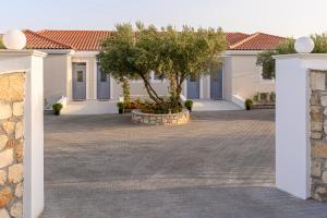 a house with a tree in the middle of a courtyard at Dionisos Suites in Lixouri