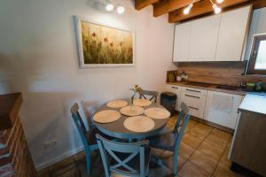 - une cuisine avec une table et des chaises dans la chambre dans l'établissement Tatarska Zagroda - Agroturystyka Dolina Baryczy Noclegi - Domek Danielek, à Krośnice