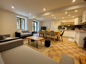 eine Küche und ein Wohnzimmer mit einem Tisch und Stühlen in der Unterkunft Le Plessis in Parçay-les-Pins