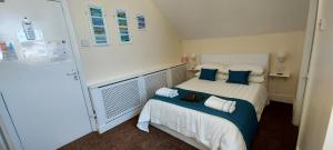 um pequeno quarto com uma cama com almofadas azuis em Ivanhoe Guest House em Bridlington