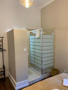 a bathroom with a shower stall and a glass door at A Portuguesa Guest House in Porto