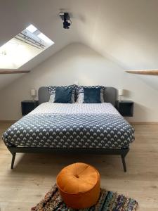 a bedroom with a bed with a blue and white comforter at Die huis 14-Een oase van rust tussen polders en kust in Ostend