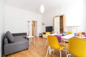 ein Wohnzimmer mit einem Tisch und gelben Stühlen in der Unterkunft Vienna Living Apartments - Raffaelgasse in Wien