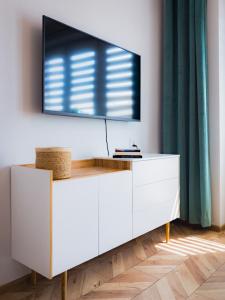 a white dresser with a television on top of it at Baszta Jacek Apartament Gdańsk in Gdańsk