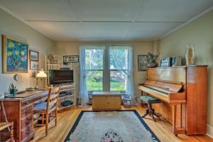 een kamer met een piano, een bureau en een raam bij Waterfront Schroon Lake Home with Boat Dock! in Schroon Lake