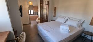 una camera da letto con un letto bianco con due cuscini sopra di Olvion Luxury Living a Kallithea