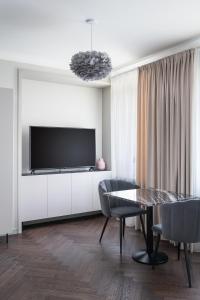 uma sala de estar com uma televisão e uma mesa e cadeiras em Place No. 2 em Vilnius