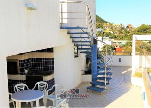 una escalera en el lateral de un edificio con mesa y sillas en 1027 - Cobertura para locação em Bombinhas com piscina - Residencial Baia Azul Apto 503 A, en Bombinhas