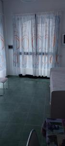 Zimmer mit weißen Vorhängen und grünem Boden in der Unterkunft la lavanda 2 in Sapri